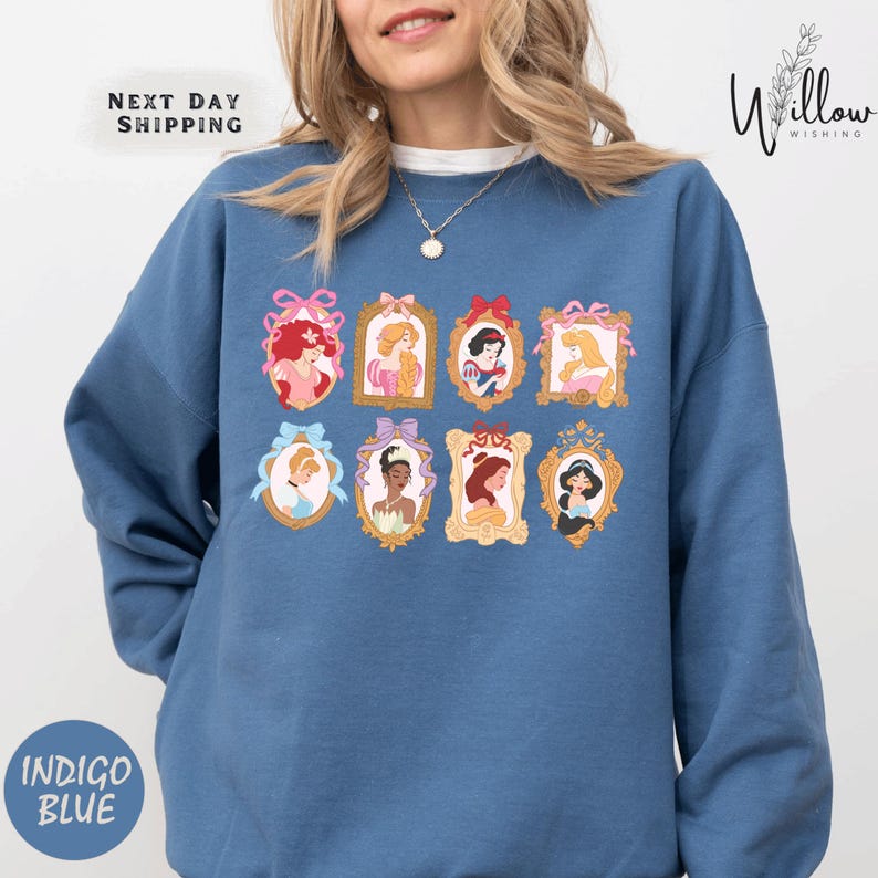 A woman wearing a blue sweatshirt with a graphic design of various Disney princesses.