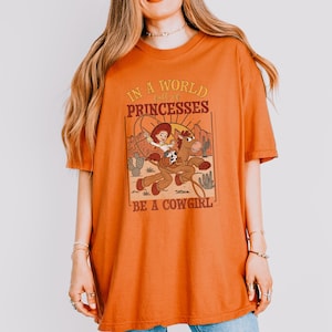 a woman wearing an orange shirt with a lion on it