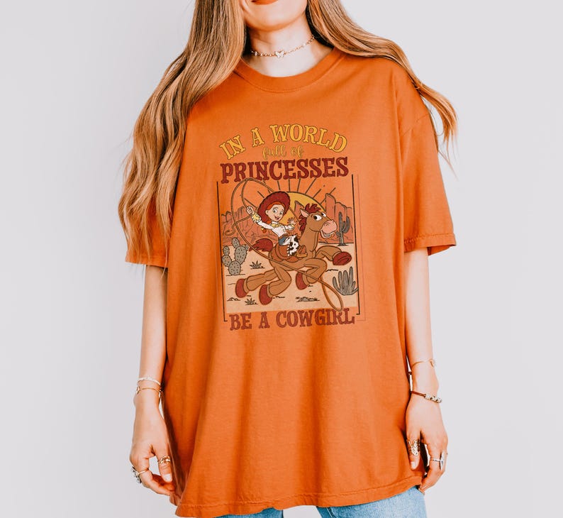 a woman wearing an orange shirt with a lion on it
