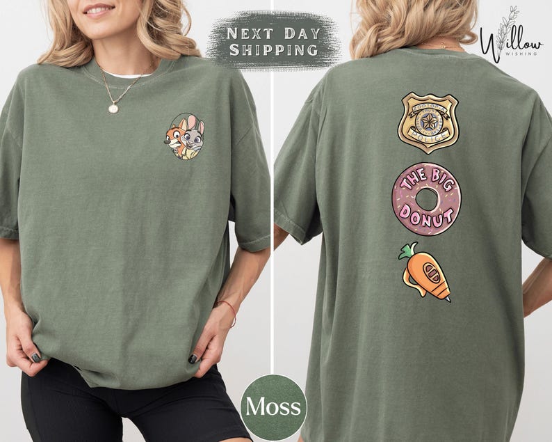 A woman wearing a green t-shirt with various cartoon characters and designs, including a police badge, a donut, and a carrot.