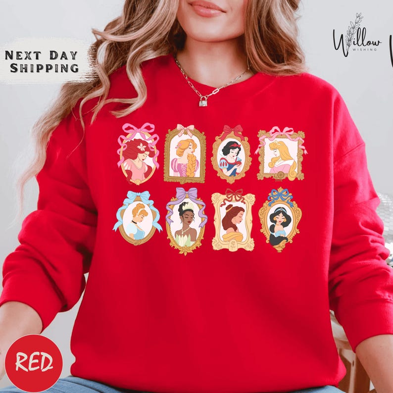 A woman wearing a red sweater with a collage of illustrations of Disney princesses on it.