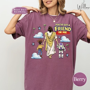 A woman wearing a purple t-shirt with a graphic design depicting a cartoon character, a young girl, and a man, along with the text "You've got a FRIEND in me".