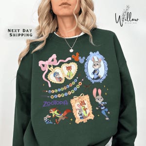 A woman wearing a green sweatshirt with various cartoon animal characters and designs printed on it.