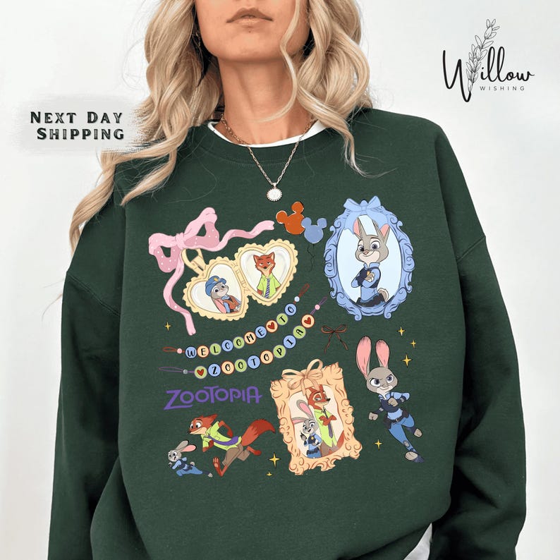 A woman wearing a green sweatshirt with various cartoon animal characters and designs printed on it.