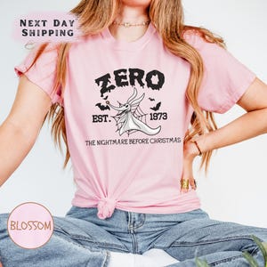 a woman wearing a pink shirt that says zero best before christmas