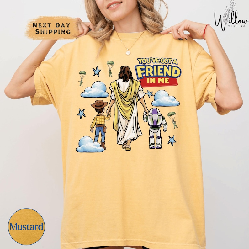 A woman wearing a yellow t-shirt with a graphic design depicting a cartoon character and a Bible verse.
