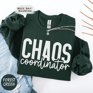 a t - shirt that says chaos coordination next to a pair of jeans