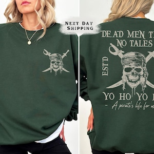May include: Dark green sweatshirt featuring a pirate skull and crossed swords design. The back of the sweatshirt displays the text "DEAD MEN TELL NO TALES" and "YO HO YO HO - A pirate's life for me".