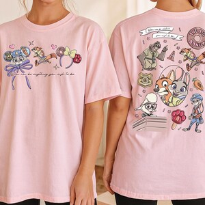 two pink t-shirts with cartoon characters and text printed on them.