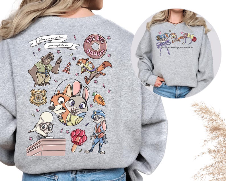 a grey sweatshirt with a colorful and whimsical design of cartoon animal characters, including a dog, cat, and rabbit, along with various other elements such as flowers, balloons, and a police officer.