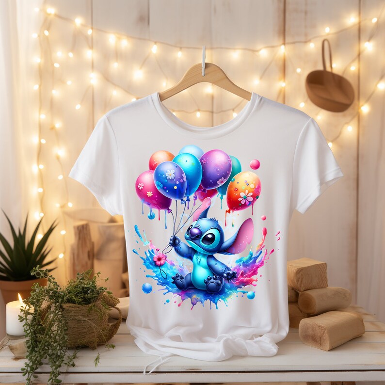 Puede incluir: Camiseta blanca con un personaje azul Stitch sosteniendo globos coloridos con un efecto acuarela.