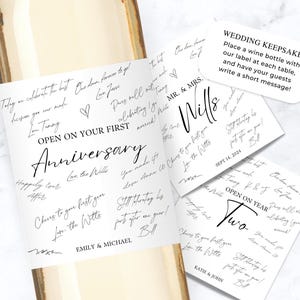 May include: A wine bottle with a white label featuring black handwritten-style text that reads OPEN ON YOUR FIRST Anniversary and EMILY & MICHAEL. Two additional square labels are shown with text including MR. & MRS. Wills and OPEN ON YEAR Two.