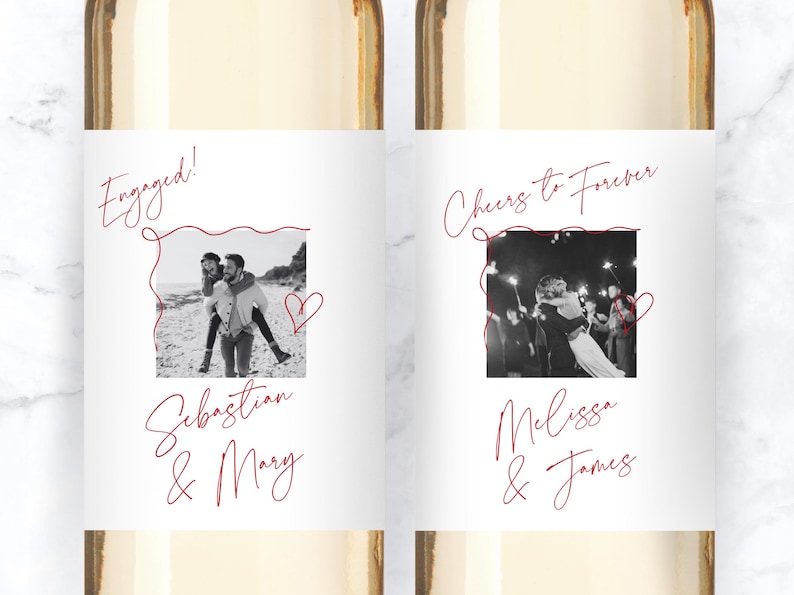 May include: Two white wine bottle labels featuring custom black and white photographs framed by red line art. The left label reads Engaged! Sebastian & Mary. The right label reads Cheers to Forever, Melissa & James, with red script text and heart icons.