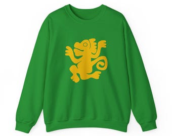 May include: A green sweatshirt featuring a gold-colored stylized monkey design. The long-sleeved crew neck top is made of a soft material. The monkey graphic is centered on the front of the shirt.