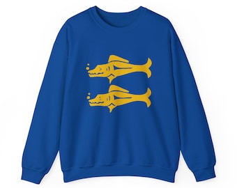 May include: Royal blue sweatshirt featuring a yellow graphic of two stylized fish. The fish are mirror images of each other, with details including fins, a mouth, and an eye. The sweatshirt is a solid color with a crew neck.