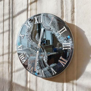 Modern black glossy wall clock on satin background