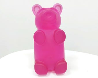 Può includere: Un contenitore di plastica a forma di orso gommoso rosa.
