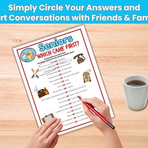 Puede incluir: Una hoja de juego impresa titulada "Seniors Which Came First?" con preguntas e ilustraciones. Una mano sostiene un bol&iacute;grafo rojo, lista para rodear las respuestas. Una taza blanca de caf&eacute; est&aacute; sobre una superficie de madera.