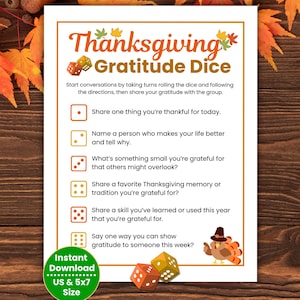 May include: A Thanksgiving Gratitude Dice printable with a festive orange border. The design includes dice graphics, a turkey illustration, and prompts for sharing gratitude. The text reads "Thanksgiving Gratitude Dice" and "Instant Download US & 5x7 Size."