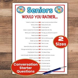 Puede incluir: Un papel blanco con bordes rojos con el texto "Seniors Would You Rather..." con preguntas para iniciar una conversación. El juego incluye opciones como ver una película o escuchar música. También se ven un bolígrafo y una pegatina "2 Sizes".