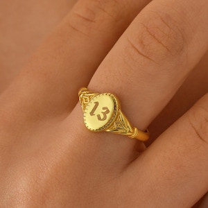 Peut inclure: Bague en or avec un serti ovale gravé du chiffre "13".
