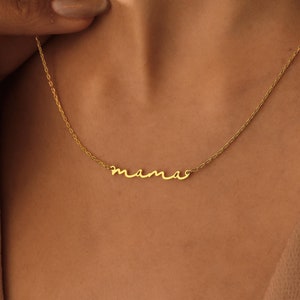 May include: A gold necklace with a cursive 'mama' pendant.