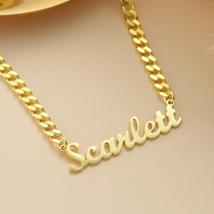 May include: Gold chain necklace with a cursive nameplate pendant that reads "Scarlett".