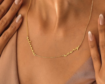 May include: A gold necklace with the words "Melina" and "Avery" written in cursive script.
