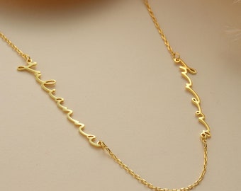 May include: A gold necklace with two names, "Julianna" and "Emma", written in cursive script.
