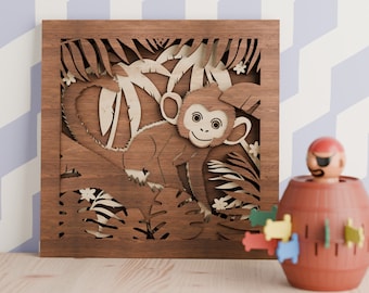 Könnte beinhalten: Eine Holz-Wanddekoration mit einem Laser-geschnittenen Design eines Affen in einer Dschungel-Szene. Der Affe ist braun und hat ein weißes Gesicht mit schwarzen Augen. Die Dschungelszene ist detailliert mit Blättern, Ranken und Blumen.
