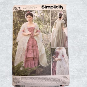 Op de afbeelding: Simplicity naaipatroon 8578 R5 voor een 18e-eeuwse jurk. De afbeelding toont een vrouw in een roze en witte jurk met een lange jas. Het patroon bevat maat informatie in US, Euro (40-48) en FR (42-50).