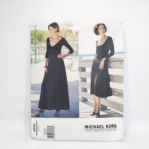 Puede incluir: Un patrón de costura para un vestido negro de Michael Kors. El diseño presenta un vestido largo y fluido con escote en V y mangas tres cuartos. La etiqueta Vogue American Designer es visible.
