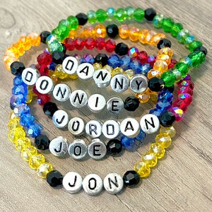 May include: Six colorful beaded bracelets with silver letter beads spelling out the names "Danny", "Donnie", "Jordan", "Joe", and "Jon".