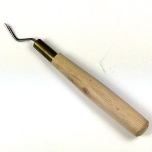 May include: A wooden handled tool with a brass ferrule and a curved metal hook. The tool is used for pulling out small objects from tight spaces.