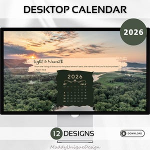 May include: A computer monitor displays a desktop calendar design for 2026. The screen shows a scenic landscape with a sunset and the text "Light & Warmth." A dark green calendar for July is visible. The words "Desktop Calendar" are at the top.