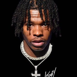 Puede incluir: Un retrato de cerca de una persona con largas rastas negras que lleva una camisa negra y una cadena de plata con un gran colgante de cruz de diamantes. La firma "Lil Baby" está escrita en blanco debajo de la cruz.