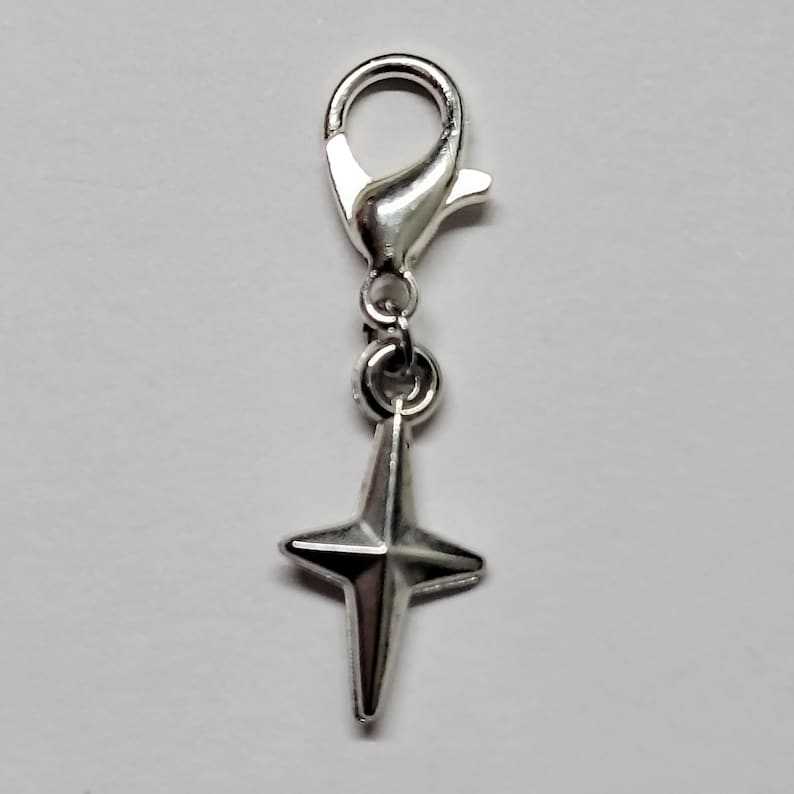 May include: Silver charm with a star-shaped pendant and a lobster clasp.