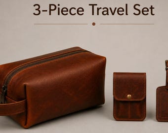 May include: A three-piece travel set made of brown leather. The set includes a rectangular toiletry bag with a handle, a small card holder, and a luggage tag. The text "3-Piece Travel Set" is at the top.