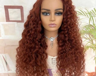 May include: A long, curly, copper-red wig with a lace front, displayed on a mannequin head. The wig features tight, voluminous ringlets that cascade down the shoulders. A silver-toned necklace with a central pendant is visible at the neck.