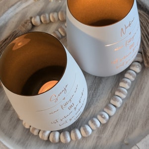 May include: Two white candle holders with gold interiors. The candle holders have personalized messages on them. The message on the left candle holder reads "Svenja, eine Kollegin wie DU ist schwer zu finden,  habt  ihr  ganz  viel  Spa&szlig;  zusammen". The message on the right candle holder reads "Nadine, eine Kollegin wie DU ist schwer zu finden,  habt  ihr  ganz  viel  Spa&szlig;  zusammen".