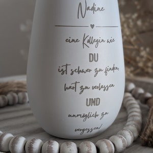May include: White ceramic tumbler with the text "Nadine" and a heart, followed by the text "eine Kollegin wie DU ist schwer zu finden, hart zu verlassen UND unm&ouml;glich zu vergessen!"