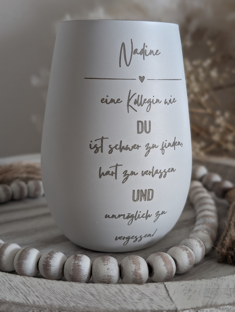 May include: White ceramic tumbler with the text "Nadine" and a heart, followed by the text "eine Kollegin wie DU ist schwer zu finden, hart zu verlassen UND unm&ouml;glich zu vergessen!"