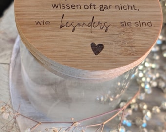 Könnte beinhalten: Ein klares Glas mit einem Holzdeckel. Der Deckel hat einen eingravierten Text und ein Herzsymbol. Der Text lautet: "Die tollsten Menschen wissen oft gar nicht, wie besonders sie sind." Getrocknete Blumen umgeben das Glas.
