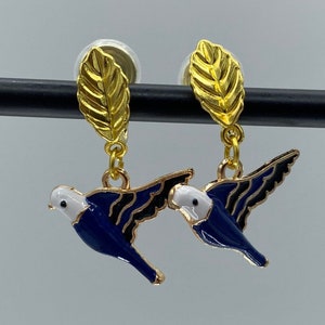 Clip on earrings with blue and gold flying birds, dangling from golden leaves