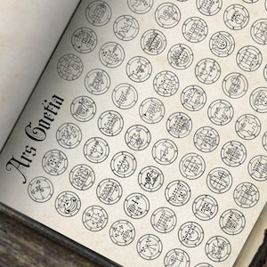 Può includere: Pagina di libro aperto con numerosi sigilli circolari neri e il titolo "Ars Goetia" in scrittura gotica. I sigilli sono finemente dettagliati, ognuno con simboli e motivi unici, su uno sfondo color crema.