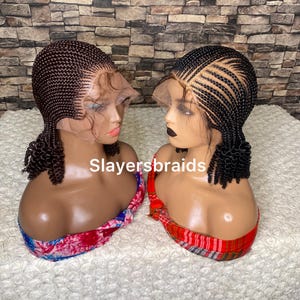 May include: Two braided wigs with a lace front, styled with small, tight curls. The wigs are on mannequin heads with red and white patterned fabric around their necks. The text "Slayersbraids" is visible in the center of the image.