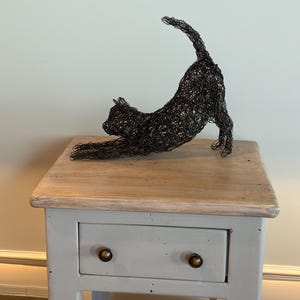 Draadsculptuur van uitrekkende kat