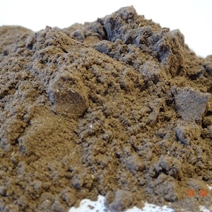 May include: A close-up shot of a mound of fine, dark brown powder. The powder has a textured, granular appearance with small clumps and variations in colour. The date "06 06 2025" is visible in the bottom right corner.