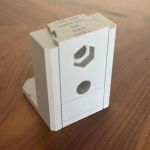 Może przedstawiać: Biały plastikowy narożnik z nadrukiem "FOR USE WITH THE ONE RAIL CHROME" na górze.