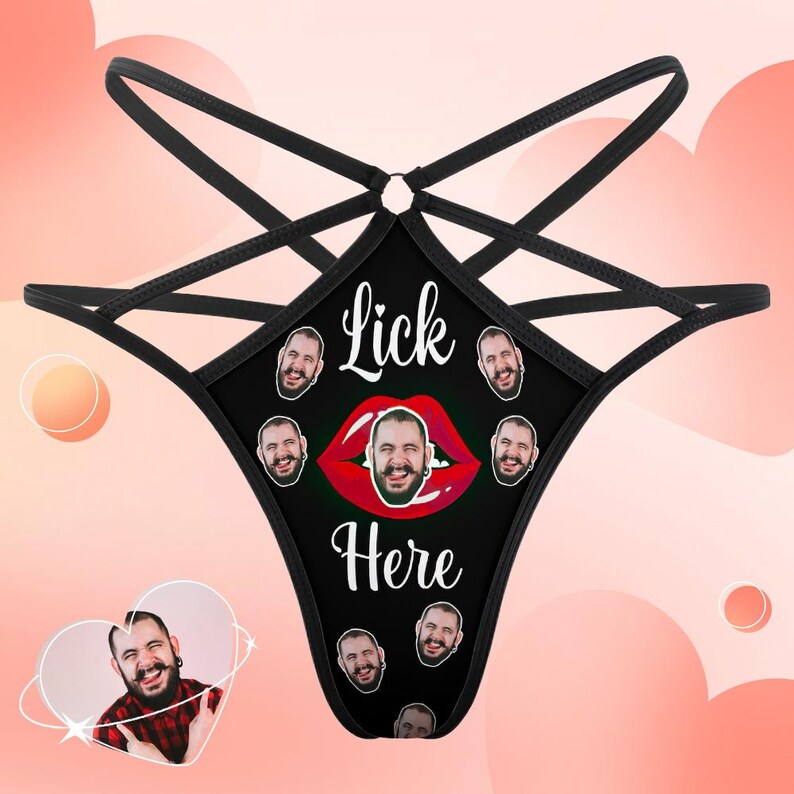 Puede incluir: Braga tanga negra con un dise&ntilde;o de correas entrecruzadas. La parte delantera presenta el texto "Lick Here" sobre un gr&aacute;fico de labios rojos con una cara en el centro, rodeada de m&uacute;ltiples caras.